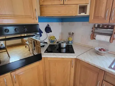 a kitchen with wooden cabinets and a stove top oven at Bovec Comfortable Apartment with Mountain View - One Bedroom Apartment with Mountain View in Bovec