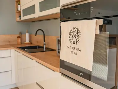 a kitchen with a kitchen new house towel on the oven at Three Bedroom Holiday Home with Terrace and Sauna in Tolmin