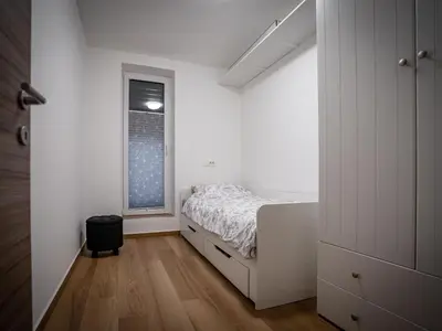 a white bedroom with a bed and a window at Three Bedroom Holiday Home with Terrace and Sauna in Tolmin