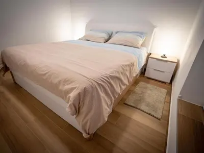 a bedroom with a bed with white sheets and a rug at Three Bedroom Holiday Home with Terrace and Sauna in Tolmin