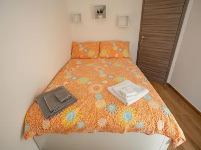a bed with an orange comforter and a tray on it at Three Bedroom Holiday Home with Terrace and Sauna in Tolmin