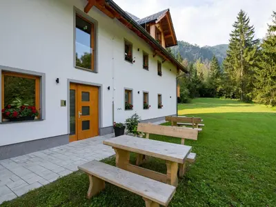 a group of benches sitting outside of a building at The Woodland Nook Apartments Bohinj - One Bedroom Apartment in Bohinj