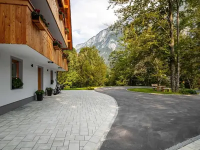 a winding road with a mountain in the background at The Woodland Nook Apartments Bohinj - One Bedroom Apartment in Bohinj
