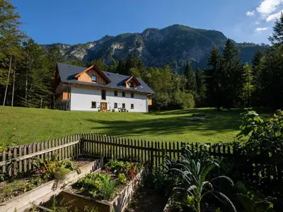 a house with a fence in front of a yard at The Woodland Nook Apartments Bohinj - One Bedroom Apartment in Bohinj