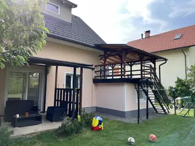 a house with a basketball hoop and a wooden structure at Meadow Tranquil Apartments with Evergreen Garden - Studio Apartment in Žirovnica