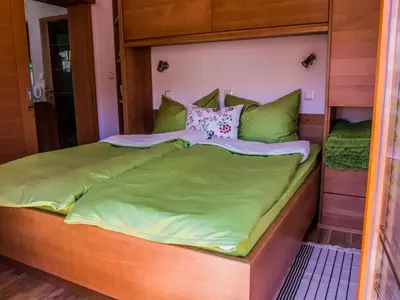 a bedroom with a bed with green sheets and pillows at Riverside Pines Luce Apartments with Balcony - One Bedroom Apartment with Balcony in Luče
