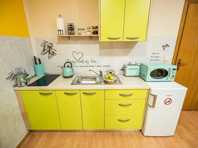 a small kitchen with yellow cabinets and a sink at Elegant and Stylish Retreat Apartments with Terrace - Studio Apartment with Terrace in Brežice