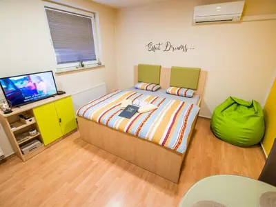 a bedroom with a bed and a flat screen tv at Elegant and Stylish Retreat Apartments with Terrace - Studio Apartment with Terrace in Brežice