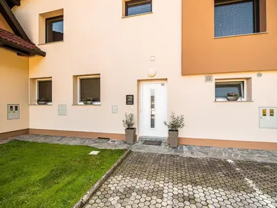 a house with a green lawn in front of it at Elegant and Stylish Retreat Apartments with Terrace - Studio Apartment with Terrace in Brežice