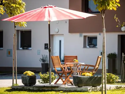 a table and two chairs under an umbrella at Elegant and Stylish Retreat Apartments with Terrace - Studio Apartment with Terrace in Brežice