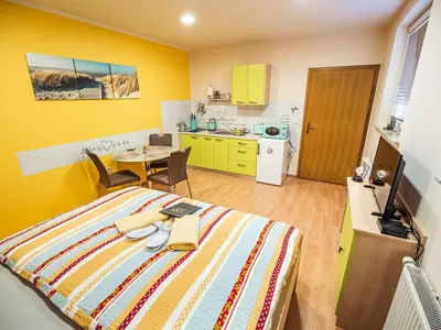 a bedroom with a bed and a table and a kitchen at Elegant and Stylish Retreat Apartments with Terrace - Studio Apartment with Terrace in Brežice