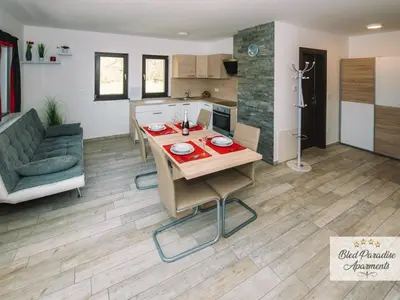 a kitchen and living room with a table and a couch at Bled Prestigious and Stylish Apartments - Classic One Bedroom Apartment with Balcony in Bled