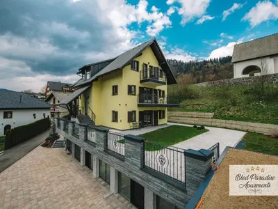 a large yellow house with a balcony at Bled Prestigious and Stylish Apartments - Classic One Bedroom Apartment with Balcony in Bled