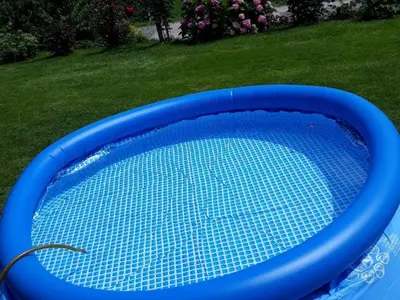 a blue swimming pool in a yard next to a lawn at Comfortable Zre e Apartment - One Bedroom Apartment in Zreče