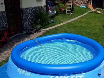 a blue pool with a net in a yard at Comfortable Zre e Apartment - One Bedroom Apartment in Zreče