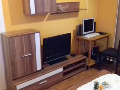 a living room with a tv and a desk with a laptop at Comfortable Zre e Apartment - One Bedroom Apartment in Zreče