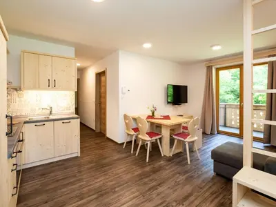 a kitchen and living room with a table and chairs at The Woodland Nook Apartments Bohinj - Classic Two Bedroom Apartment with Balcony in Bohinj