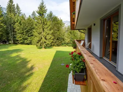 a porch of a house with a garden at The Woodland Nook Apartments Bohinj - Classic Two Bedroom Apartment with Balcony in Bohinj