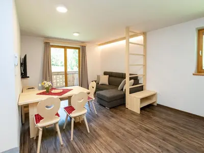 a living room with a couch and a table and chairs at The Woodland Nook Apartments Bohinj - Classic Two Bedroom Apartment with Balcony in Bohinj