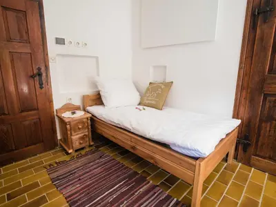 a bed with white sheets and pillows in a room at Rustic Authentic Holiday Home with Terrace and Wood Stove - Three Bedroom Holiday Home with Terrace in Ljubno