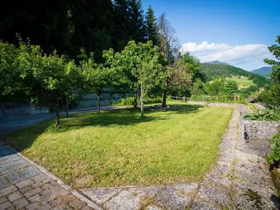 a garden with trees and a stone path at Rustic Authentic Holiday Home with Terrace and Wood Stove - Three Bedroom Holiday Home with Terrace in Ljubno
