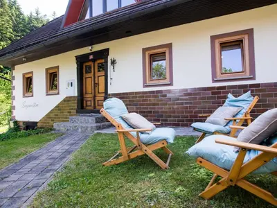 a group of chairs sitting outside of a house at Rustic Authentic Holiday Home with Terrace and Wood Stove - Three Bedroom Holiday Home with Terrace in Ljubno