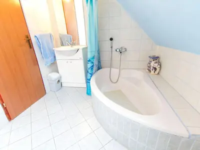 a white bathroom with a tub and a sink at Rustic Charm Cottage Country House with Sauna - Five Bedroom Holiday Home with Sauna in Bizeljsko