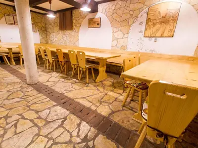 a row of wooden tables and chairs in a room at Rustic Charm Cottage Country House with Sauna - Five Bedroom Holiday Home with Sauna in Bizeljsko