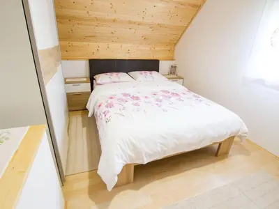 a bedroom with a large bed with a wooden ceiling at Sunny Two Bedroom Retreat in Beautiful Bizeljsko - Two Bedroom Country House in Bizeljsko