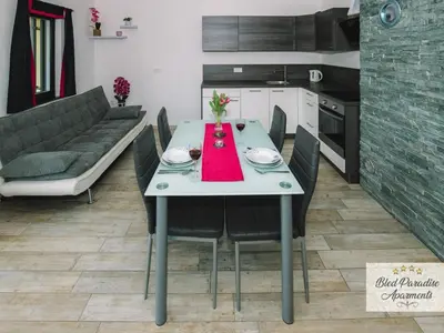 a dining room with a table and a couch at Bled Prestigious and Stylish Apartments - Standard Studio Apartment with Terrace in Bled