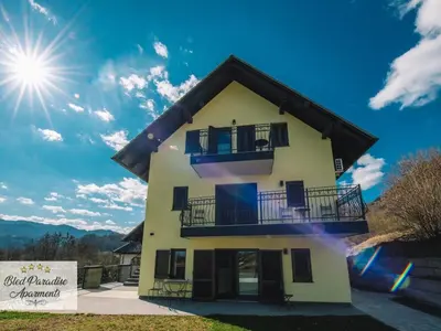 a house with a balcony and the sun in the sky at Bled Prestigious and Stylish Apartments - Standard Studio Apartment with Terrace in Bled
