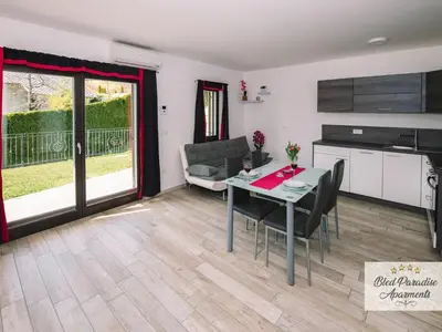 a kitchen and a dining room with a table and chairs at Bled Prestigious and Stylish Apartments - Standard Studio Apartment with Terrace in Bled