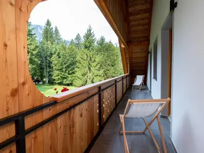 a wooden balcony with a chair and a window at The Woodland Nook Apartments Bohinj - Comfort Two Bedroom Apartment with Balcony in Bohinj