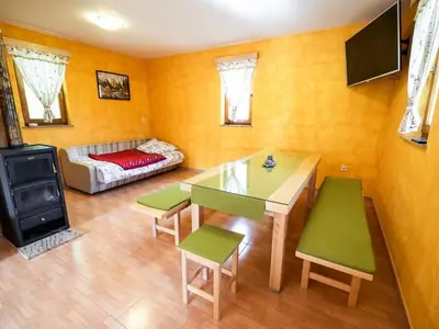 a living room with a table and chairs and a couch at One Bedroom Holiday Home with Terrace and Garden in Krška Vas