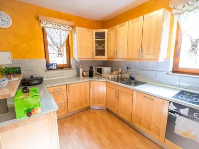 a kitchen with wooden cabinets and a counter top at One Bedroom Holiday Home with Terrace and Garden in Krška Vas