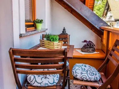 a porch with a table and two chairs and a table and a tableablish at Riverside Pines Luce Apartments with Balcony - Studio Apartment with Balcony in Luče