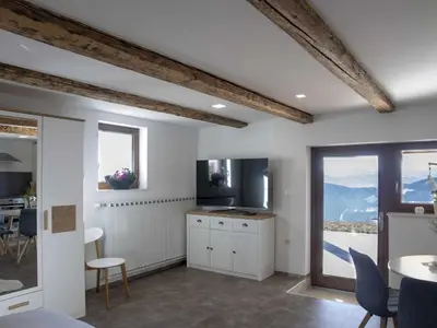 a kitchen with white walls and a table and chairs at Mountain Vibrant and Timeless Apartment with Sauna - Studio Apartment with Terrace in Dravograd