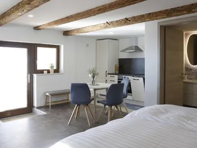 a bedroom with a bed and a table and chairs at Mountain Vibrant and Timeless Apartment with Sauna - Studio Apartment with Terrace in Dravograd