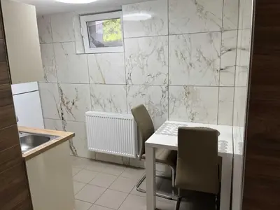 a kitchen with a table and chairs in a room at Meadow Tranquil Apartments with Evergreen Garden - One Bedroom Apartment in Žirovnica