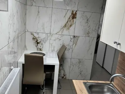 a kitchen with a table and chairs and a sink at Meadow Tranquil Apartments with Evergreen Garden - One Bedroom Apartment in Žirovnica