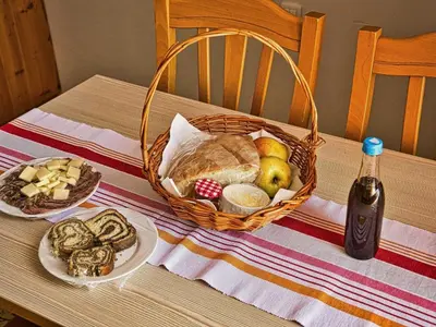a table with a basket of bread and a bottle of wine at Visnja Gora Meadow Hideaway with Terrace - One Bedroom Cottage with Terrace in Višnja Gora