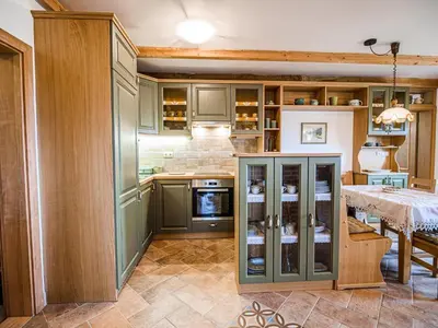 a kitchen with green cabinets and a table with a dining room at Hidden Authentic Haven Apartments - Two Bedroom Apartment with Balcony in Sevnica
