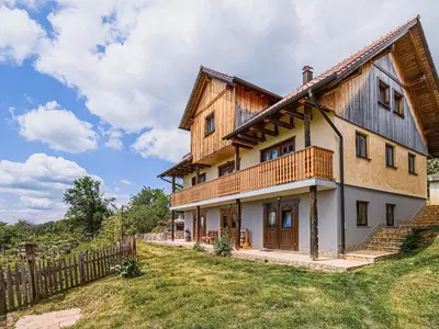 a large wooden house with a fence at Hidden Authentic Haven Apartments - Two Bedroom Apartment with Balcony in Sevnica