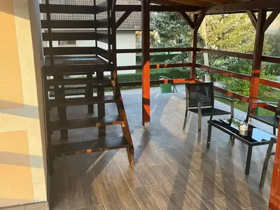 a loft bed in a room with a table and a chair at Meadow Tranquil Apartments with Evergreen Garden - Two Bedroom Apartment in Žirovnica