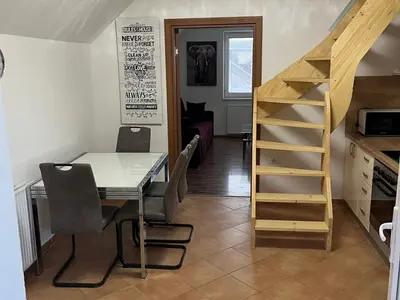 a small room with a table and a staircase at Meadow Tranquil Apartments with Evergreen Garden - Two Bedroom Apartment in Žirovnica