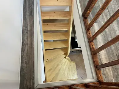 a staircase in a house with wooden steps at Meadow Tranquil Apartments with Evergreen Garden - Two Bedroom Apartment in Žirovnica