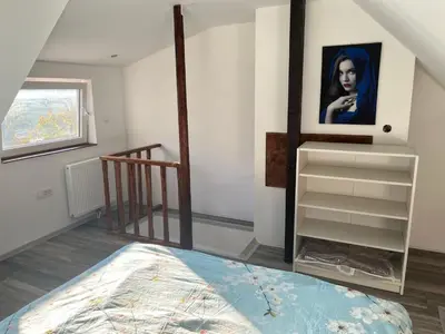 a bedroom with a bed and a painting on the wall at Meadow Tranquil Apartments with Evergreen Garden - Two Bedroom Apartment in Žirovnica