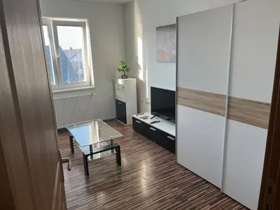 a living room with a glass table and a cabinet at Meadow Tranquil Apartments with Evergreen Garden - Two Bedroom Apartment in Žirovnica