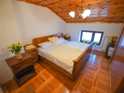a bedroom with a large bed and a wooden floor at Cozy Luxe Holiday Home with Natural Thermal Bath - Seven Bedroom Holiday Home in Cerklje ob Krki