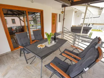 a patio with a table and chairs on a porch at Cozy Luxe Holiday Home with Natural Thermal Bath - Seven Bedroom Holiday Home in Cerklje ob Krki